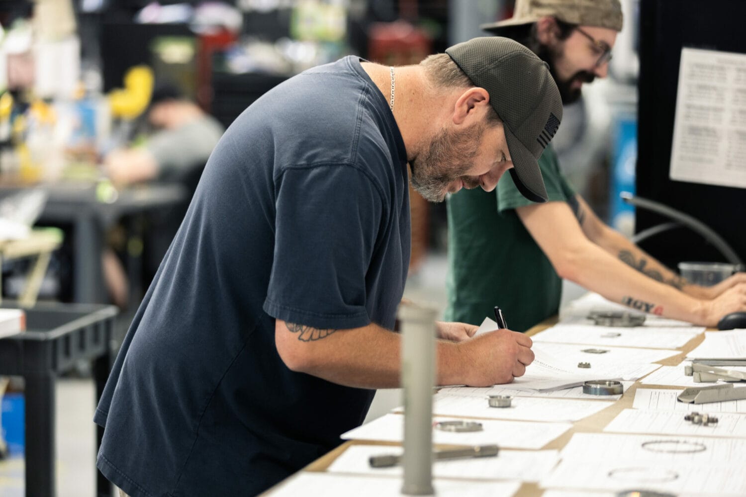 Aerospace technicians inspecting and documenting components in a precision manufacturing facility, ensuring quality standards for corporate aircraft operators and effective inventory management.