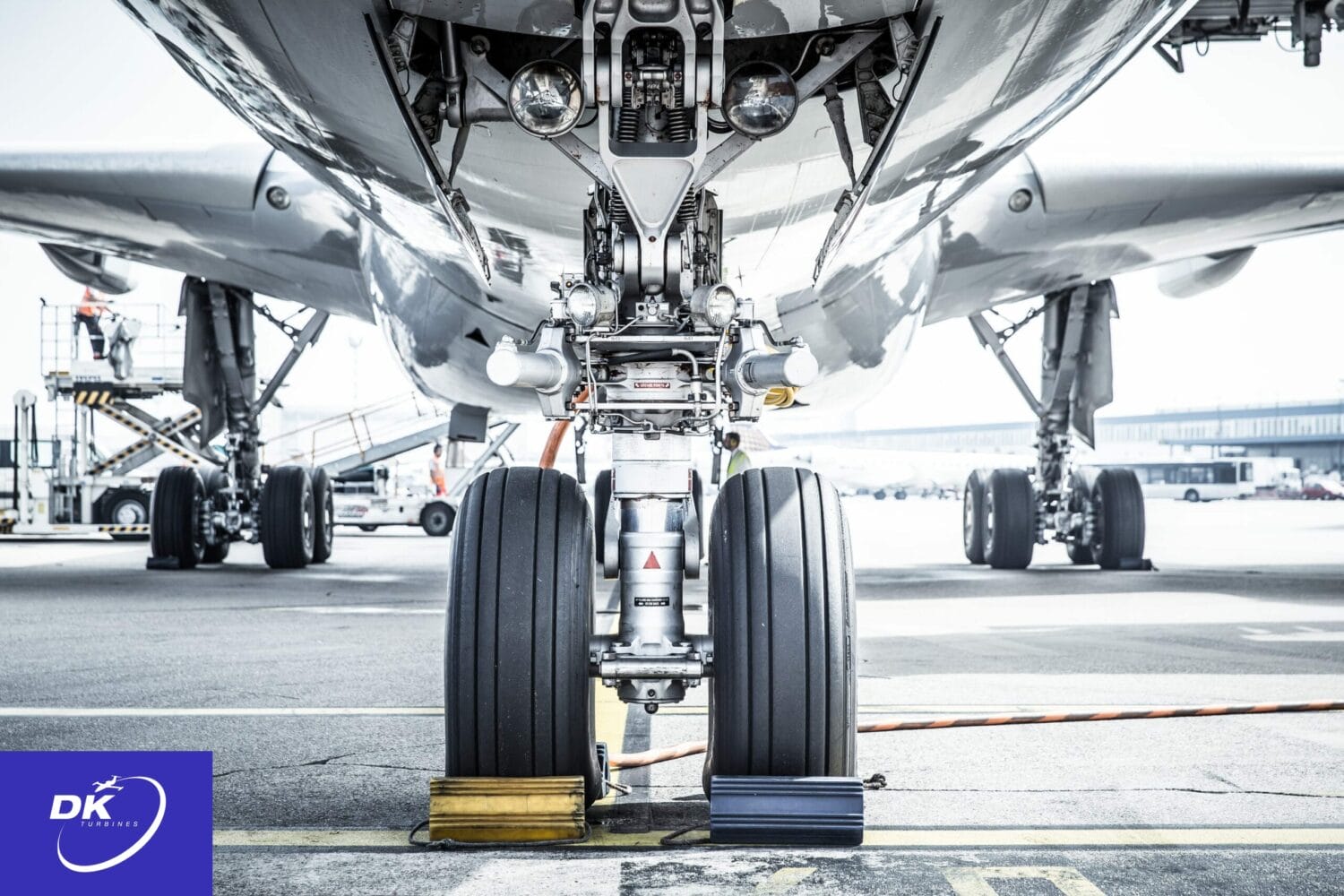 Aircraft wheel chocks placed securely against the landing gear wheels to prevent movement while parked on the tarmac.