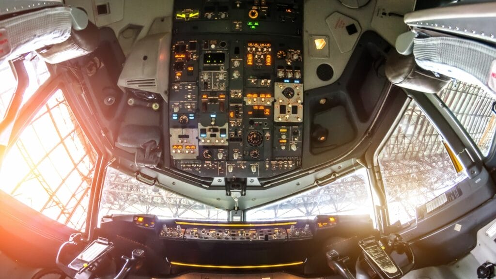 Modern aircraft cockpit with controls and flight instruments.